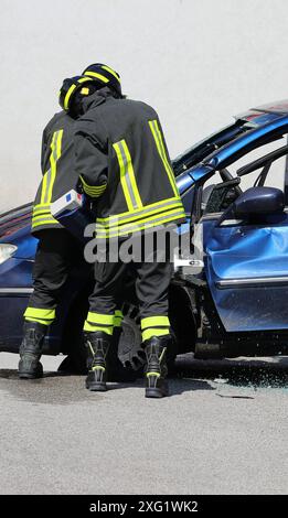 I vigili del fuoco utilizzano uno strumento di salvataggio idraulico chiamato Jaws of Life per aprire la porta di un'auto che si è schiantata Foto Stock