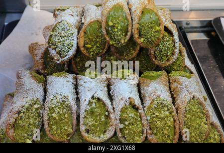 Molti cannoli siciliani ripieni di Ricotta e pistacchi in vendita in Sicilia Foto Stock