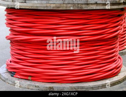 grande bobina di cavo elettrico rosso isolato ad alta tensione nel magazzino delle società elettriche Foto Stock