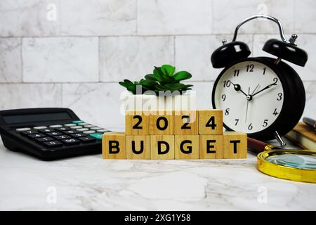 Budget 2024 con blocchi di legno lettere alfabetiche e accessori di cancelleria su sfondo in marmo Foto Stock