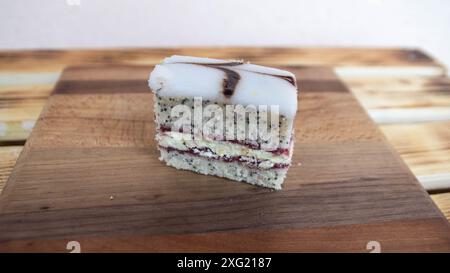 Torta a strati con spugne di semi papavero con ripieno di marmellata e panna e glassa di zucchero Foto Stock