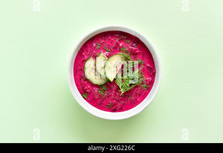 Zuppa di barbabietole fredda estiva nel recipiente su sfondo verde. Disintossicazione sana o concetto di cibo vegetariano. Vista dall'alto, disposizione piatta Foto Stock