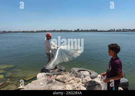 Rasheed, Egitto. 27 giugno 2024. Un pescatore egiziano locale getta la sua rete pesata nel fiume Nilo a Rosetta nel delta del Nilo nell'Egitto settentrionale. Rosetta conosciuta localmente come Rashid è una città portuale del delta del Nilo, la pietra di Rosetta fu scoperta lì nel 1799. (Credit Image: © John Wreford/SOPA Images via ZUMA Press Wire) SOLO PER USO EDITORIALE! Non per USO commerciale! Foto Stock