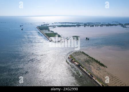 Hunan, Cina. 6 luglio 2024. (240706) -- YUEYANG, 6 luglio 2024 (Xinhua) -- una foto di un drone aereo scattata il 6 luglio 2024 mostra il sito di una breccia di diga nella città di Tuanzhou, nella contea di Huarong sotto la città di Yueyang, nella provincia di Hunan della Cina centrale. Secondo il Ministero della gestione delle emergenze, un team di lavoro è stato inviato nella provincia di Hunan della Cina centrale per guidare gli sforzi di salvataggio dopo una diga nel secondo lago d'acqua dolce più grande del paese il venerdì pomeriggio. Più di 800 persone del China National Comprehensive Fire and Rescue Team, 146 veicoli e 82 barche sono state inviate al Foto Stock