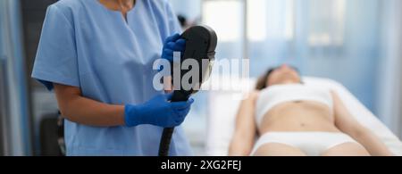 Beautician tenendo macchina ibrida di rimozione dei capelli del laser in primo piano del salone di bellezza Foto Stock