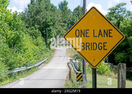 Un cartello per il Lane Bridge lungo una corsia di campagna con barriere di sicurezza Foto Stock
