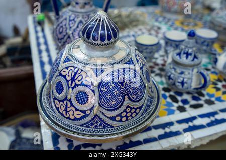 FES, Marocco - 23 marzo 2024: Una vista ravvicinata di un vaso splendidamente realizzato con motivi blu e bianchi dettagliati, circondato da varie fasi della pentola Foto Stock