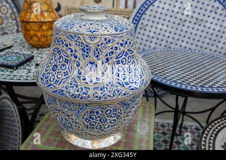 FES, Marocco - 23 marzo 2024: Una vista ravvicinata di un vaso splendidamente realizzato con motivi blu e bianchi dettagliati, circondato da varie fasi della pentola Foto Stock