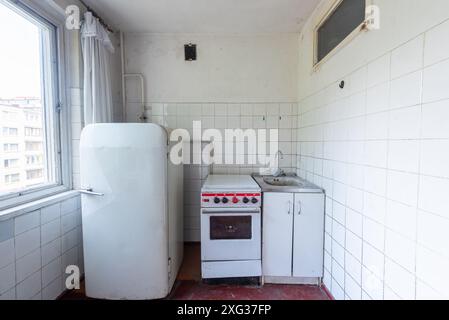 Cucina in cattive condizioni in un edificio abbandonato. Casa abbandonata all'interno. Camera sporca. Il vecchio russo russo povero interno. Foto Stock