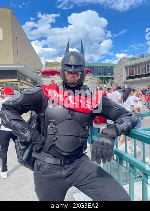 Berlino, Germania. 6 luglio 2024. Un uomo vestito da Batman che indossa una sciarpa con l'iscrizione: "I cuori sono rossi e bianchi" sta con gli altri fan sul Kudamm. Credito: -/dpa/Alamy Live News Foto Stock