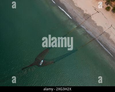 Vista aerea dei pescatori che catturano pesci usando la rete nell'oceano Foto Stock