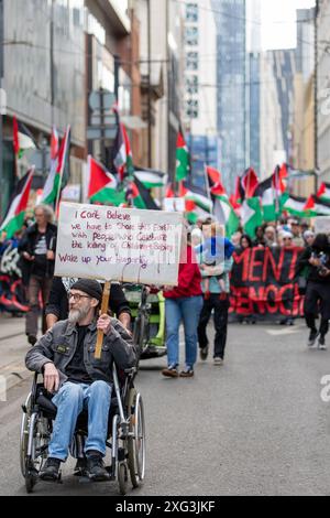 Manchester, Regno Unito. 6 luglio 2024. Proteggi in sedia a rotelle. La protesta palestinese contro la guerra di gaza a Manchester si svolge sabato dopo le elezioni generali del Regno Unito di giovedì. I manifestanti hanno marciato attraverso il centro di Manchester e hanno dovuto attraversare le donne che protestavano contro la produzione di latte con i poster "il latte non è umano". Manchester. Credito britannico: GaryRobertsphotography/Alamy Live News Foto Stock