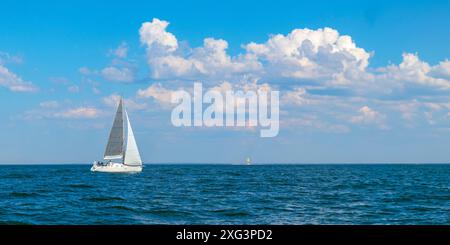 Yacht, barca a vela bianca sotto la testa di genova e vele principali navigando in un mare aperto calmo. Crociera, vacanze, regata, sport. Golfo di Finlandia Foto Stock