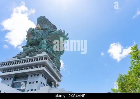 La statua di Lord Wishnu sullo sfondo di un cielo blu nuvoloso al Parco culturale Garuda Wisnu Kencana a Bali, Indonesia. Copia immagine spazio Foto Stock