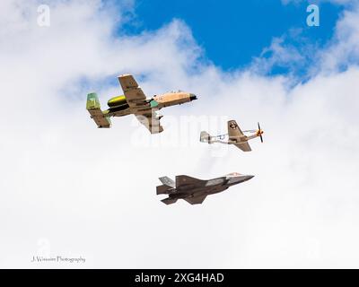 Aerei moderni e d'epoca volano in formazione in una fiera aerea militare negli Stati Uniti, così come taxi nelle vicinanze per un look migliore Foto Stock