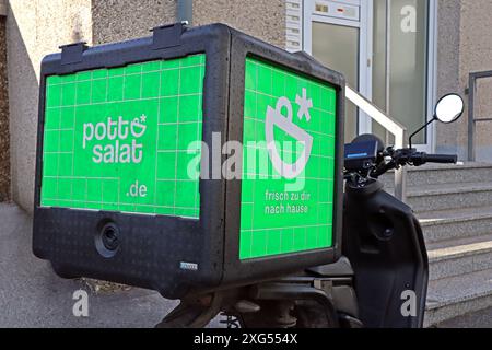 Lieferservice von Schnellrestaurants Ein Roller vom Essener Unternehmen Pottsalat ist mit bestellten Mahlzeiten unterwegs. *** Servizio di consegna da ristoranti fast food Uno scooter della società di Essen Pottsalat è sulla strada con pasti ordinati Foto Stock