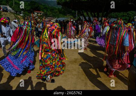 All'inizio della celebrazione del Corpus Christi a Atánquez, dipartimento di Cesar, Colombia, i gruppi di Negritos y Las Negritas ballano gioiosamente a Plaza del Coco. Las Negritas indossa abiti colorati, eleganti copricapi, mentre i Negritos indossano cappelli e spade di legno, aggiungendo un elemento dinamico e festoso al vivace patrimonio culturale della comunità Kankuamo. Foto Stock