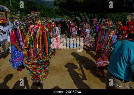 All'inizio della celebrazione del Corpus Christi a Atánquez, dipartimento di Cesar, Colombia, i gruppi di Negritos y Las Negritas ballano gioiosamente a Plaza del Coco. Las Negritas indossa abiti colorati, eleganti copricapi, mentre i Negritos indossano cappelli e spade di legno, aggiungendo un elemento dinamico e festoso al vivace patrimonio culturale della comunità Kankuamo. Foto Stock