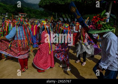 All'inizio della celebrazione del Corpus Christi a Atánquez, dipartimento di Cesar, Colombia, i gruppi di Negritos y Las Negritas ballano gioiosamente a Plaza del Coco. Las Negritas indossa abiti colorati, eleganti copricapi, mentre i Negritos indossano cappelli e spade di legno, aggiungendo un elemento dinamico e festoso al vivace patrimonio culturale della comunità Kankuamo. Foto Stock