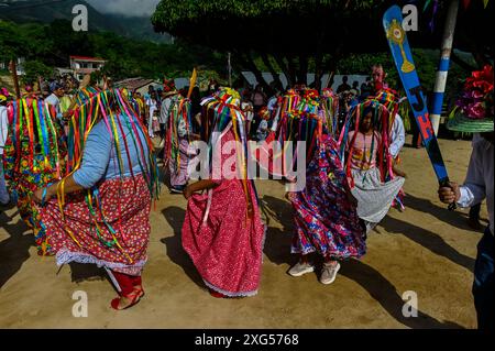 All'inizio della celebrazione del Corpus Christi a Atánquez, dipartimento di Cesar, Colombia, i gruppi di Negritos y Las Negritas ballano gioiosamente a Plaza del Coco. Las Negritas indossa abiti colorati, eleganti copricapi, mentre i Negritos indossano cappelli e spade di legno, aggiungendo un elemento dinamico e festoso al vivace patrimonio culturale della comunità Kankuamo. Foto Stock