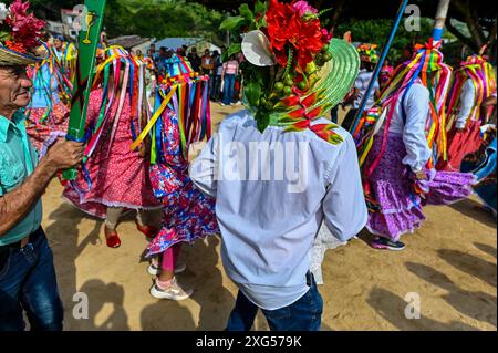 All'inizio della celebrazione del Corpus Christi a Atánquez, dipartimento di Cesar, Colombia, i gruppi di Negritos y Las Negritas ballano gioiosamente a Plaza del Coco. Las Negritas indossa abiti colorati, eleganti copricapi, mentre i Negritos indossano cappelli e spade di legno, aggiungendo un elemento dinamico e festoso al vivace patrimonio culturale della comunità Kankuamo. Foto Stock