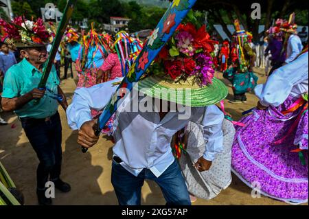 All'inizio della celebrazione del Corpus Christi a Atánquez, dipartimento di Cesar, Colombia, i gruppi di Negritos y Las Negritas ballano gioiosamente a Plaza del Coco. Las Negritas indossa abiti colorati, eleganti copricapi, mentre i Negritos indossano cappelli e spade di legno, aggiungendo un elemento dinamico e festoso al vivace patrimonio culturale della comunità Kankuamo. Foto Stock