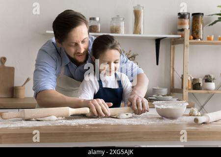 Il papà amorevole insegna alla sua piccola figlia le abilità culinarie Foto Stock