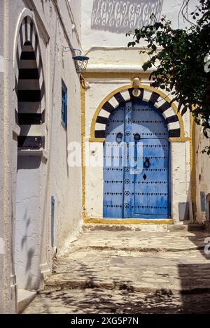 La Tunisia, Sidi Bou Said. Blue porta a casa privata, in bianco e nero arco in pietra. La porta alta battenti data dal momento in cui gli ospiti sono arrivati a cavallo. Foto Stock