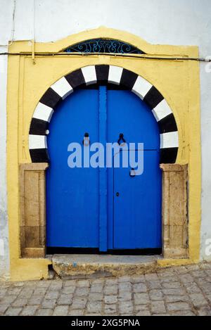 La Tunisia, Sidi Bou Said. Decorate in blu porta, in bianco e nero arco in pietra. La porta alta battenti data dal momento in cui gli ospiti sono arrivati a cavallo. Foto Stock