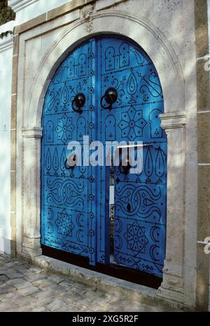 La Tunisia, Sidi Bou Said. Porta ad un cortile di famiglia. La maggiore coppia di porte battenti date dal momento in cui gli ospiti sono arrivati a cavallo. Foto Stock