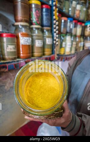 Venditore di spezie con barattolo di curcuma, Essaouira, marocco Foto Stock