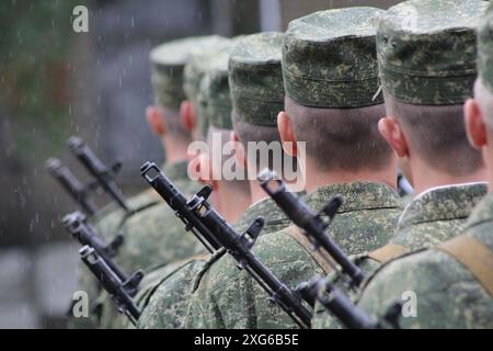 Soldati con fucili d'assalto da dietro. soldati in formazione e con fucili automatici in uniforme verde mimetica Foto Stock