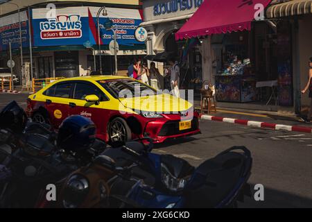 Thailandia. Taxi locale di Phuket di colore giallo e rosso nella città vecchia con sino-portoghese. Strada trafficata. Negozi e ristoranti nella città vecchia. Attrazione turistica Foto Stock