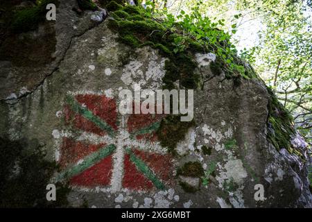 Bandiera basca dipinta sulla roccia, ikurrina, sentiero GR 20 - percorso circolare per Aralar, parco naturale Aralar, Guipuzcoa-Navarra, Spagna. Foto Stock