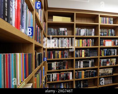 Cracovia. Cracovia. Polonia. Scaffali della biblioteca pieni di libri disponibili per il prestito presso la biblioteca pubblica locale. Foto Stock