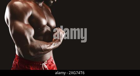 Biceps Flexing Man su sfondo nero Foto Stock