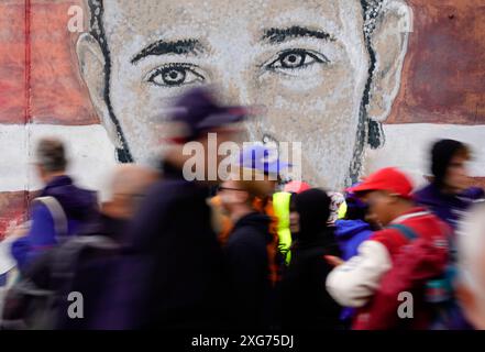 Gli spettatori passano un murale di Lewis Hamilton prima della gara al circuito di Silverstone, Northamptonshire. Data foto: Domenica 7 luglio 2024. Foto Stock