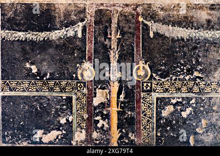 Dettaglio di un affresco con decorazione su sfondo nero in una domus a Pompei Foto Stock