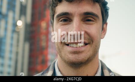 Primo piano ritratto uomo caucasico felice gioioso ragazzo positivo modello bel 30 uomo millenario in città all'aperto guardando la fotocamera sorriso sincero dentale Foto Stock