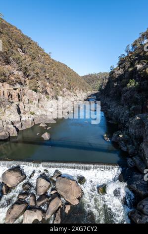 L'acqua passa sotto il ponte pedonale sospeso di Alexandra nella riserva Cataract Gorge a Launceston, Tasmania, Australia. La riserva è popolare Foto Stock