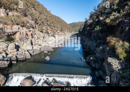 L'acqua passa sotto il ponte pedonale sospeso di Alexandra nella riserva Cataract Gorge a Launceston, Tasmania, Australia. La riserva è popolare Foto Stock