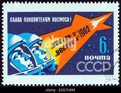 URSS - 1962 CIRCA: Un francobollo stampato in URSS dal numero "First Group Space Flight" mostra i cosmonauti in volo Foto Stock