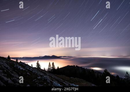 Vista notturna da Vaud Jura con Star Trails e Glow notturno sotto uno strato di nebbia Foto Stock