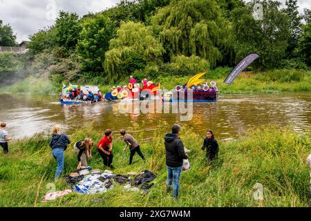 Lewes, Regno Unito. 7 luglio 2024. La gente del posto, in zattere fatte in casa, partecipa alla Lewes Raft Race sul fiume Ouse da Lewes a Newhaven. La Raft Race è un evento annuale organizzato da Lewes Round Table in aiuto di enti di beneficenza locali. Tradizionalmente, gli spettatori si allineano sulla riva del fiume e gettano uova e farina alle zattere con la gente sulle zattere che si protegge con scudi fatti in casa. Credito: Grant Rooney/Alamy Live News Foto Stock