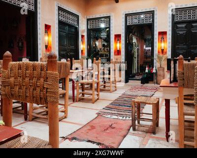 Accogliente ristorante tradizionale con mobili rustici in legno, sedie intrecciate e calda illuminazione a lanterna. Invitante e culturale esperienza culinaria in un affascinante Foto Stock