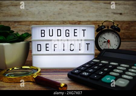 Testo della carta intestata PER DEFICIT DI BUDGET su Lightbox LED su sfondo in legno, sfondo del concetto Business and Finance Foto Stock