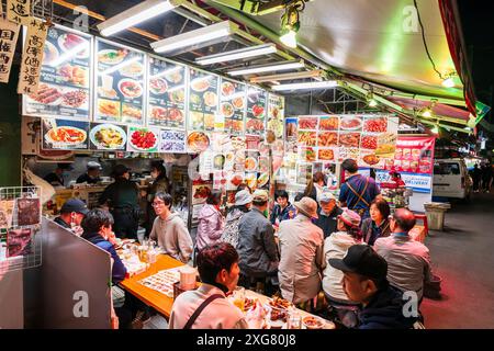 I commensali seduti ai tavoli sul marciapiede fuori da un ristorante cinese in serata nel popolare quartiere della vita notturna di Ueno Ameyoko, Tokyo. Foto Stock