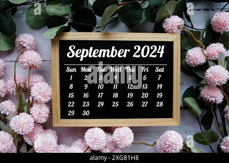 Calendario mensile di settembre 2024 con bouquet di fiori su sfondo di legno Foto Stock