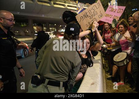 Tel Aviv, Israele. 6 luglio 2024. La polizia israeliana solleva un manifestante dall'autostrada Ayalon durante la manifestazione. Oltre 100.000 israeliani hanno manifestato a Kaplan con le famiglie degli ostaggi contro il primo ministro Benjamin Netanyahu, chiedendo un accordo immediato con gli ostaggi e il cessate il fuoco, durante la manifestazione, i manifestanti hanno bloccato l'autostrada Ayalon e sono stati dispersi da un cannone d'acqua della polizia. Credito: SOPA Images Limited/Alamy Live News Foto Stock