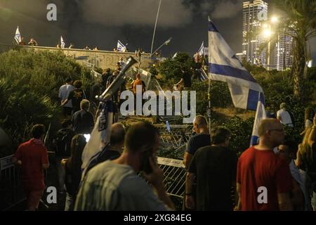 Tel Aviv, Israele. 6 luglio 2024. I manifestanti israeliani salgono attraverso recinzioni cadute dall'autostrada Ayalon dopo il blocco di itís durante la manifestazione. Oltre 100.000 israeliani hanno manifestato a Kaplan con le famiglie degli ostaggi contro il primo ministro Benjamin Netanyahu, chiedendo un accordo immediato con gli ostaggi e il cessate il fuoco, durante la manifestazione, i manifestanti hanno bloccato l'autostrada Ayalon e sono stati dispersi da un cannone d'acqua della polizia. Credito: SOPA Images Limited/Alamy Live News Foto Stock